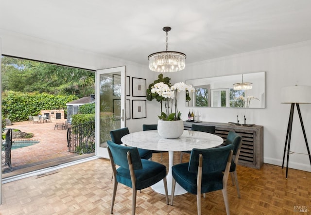 dining room featuring a chandelier, baseboards, visible vents, and crown molding