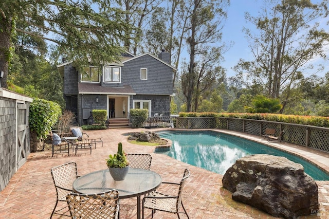 view of swimming pool featuring a fenced in pool, a patio area, and fence