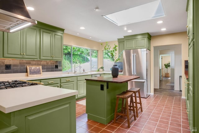 5 Madrone Ave, Woodacre, CA 94973 - kitchen with green cabinetry, decorative backsplash, ventilation hood, and freestanding refrigerator