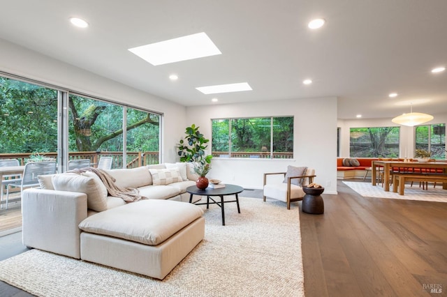 living room with wood-type flooring, a skylight, and recessed lighting