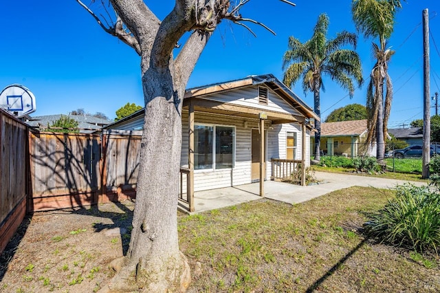 view of front of home with a patio, a front lawn, and fence private yard