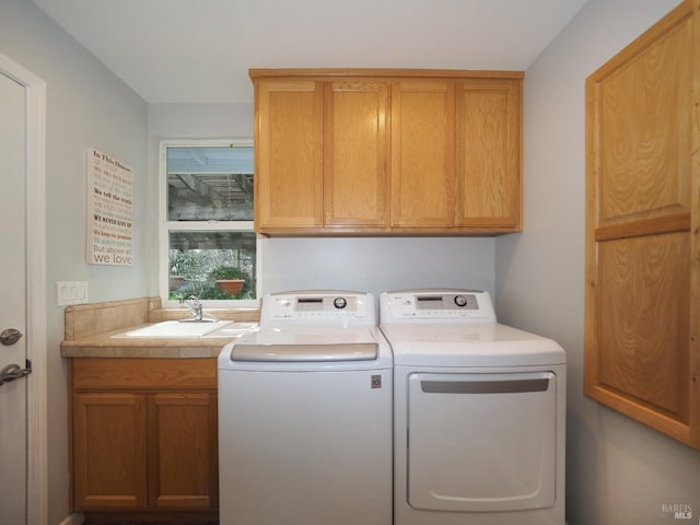 laundry area featuring a sink, cabinet space, and independent washer and dryer