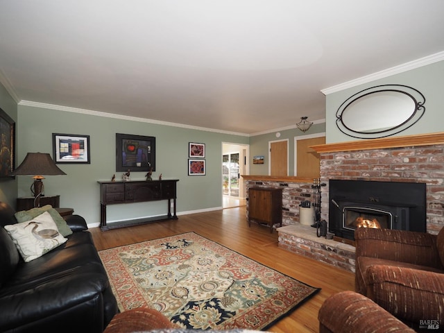 living area with a brick fireplace, crown molding, baseboards, and wood finished floors