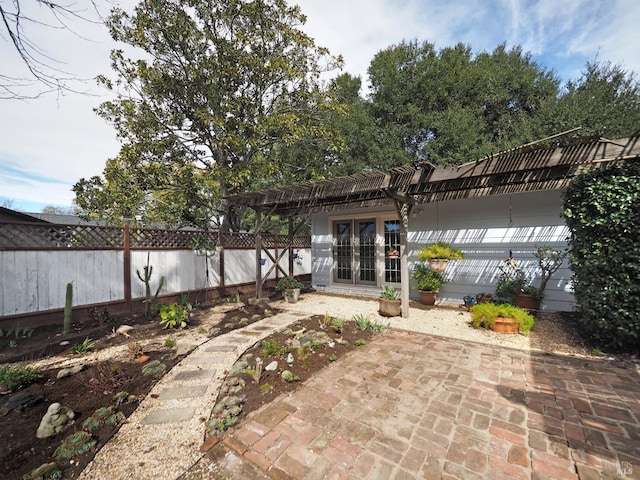 rear view of house featuring a patio area, french doors, a pergola, and a fenced backyard