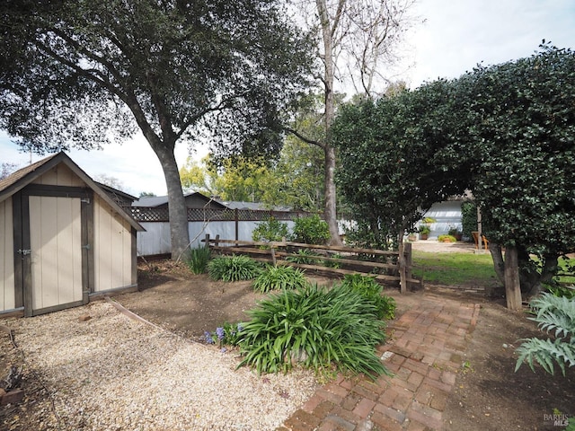 view of yard with an outdoor structure, a shed, and fence