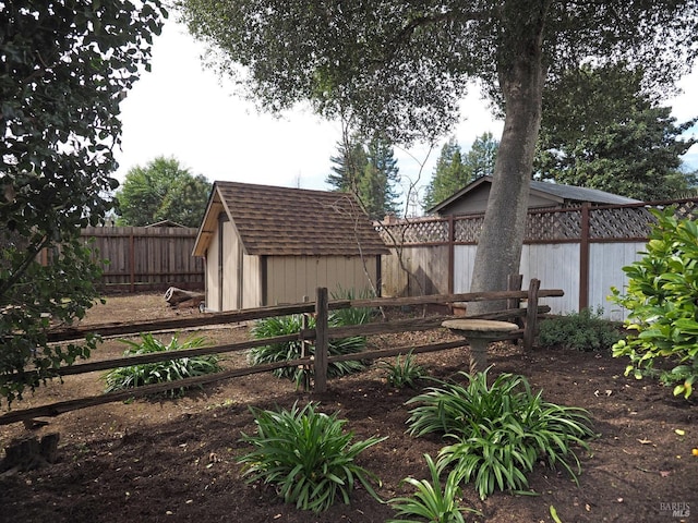 view of yard with an outbuilding, a storage unit, and a fenced backyard