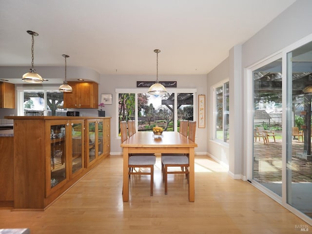 dining area featuring light wood-style floors and baseboards