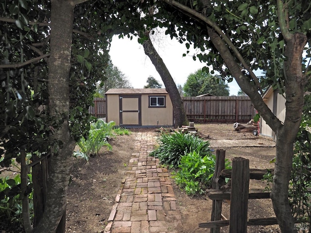 view of yard with a fenced backyard, an outdoor structure, and a shed