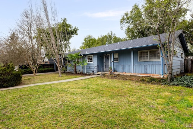 ranch-style house featuring a shingled roof and a front yard