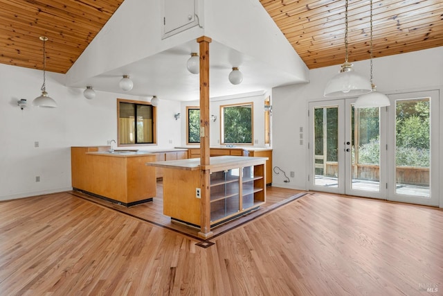 kitchen featuring light wood-type flooring, wood ceiling, hanging light fixtures, and french doors