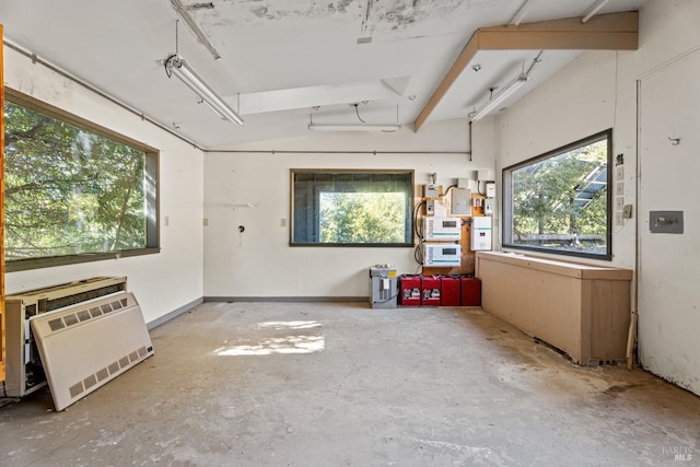 miscellaneous room featuring heating unit and unfinished concrete floors