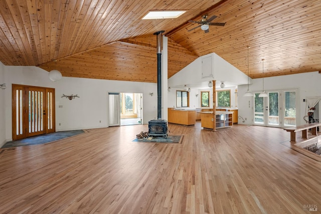 unfurnished living room featuring wood ceiling, high vaulted ceiling, light wood-style flooring, and a wood stove