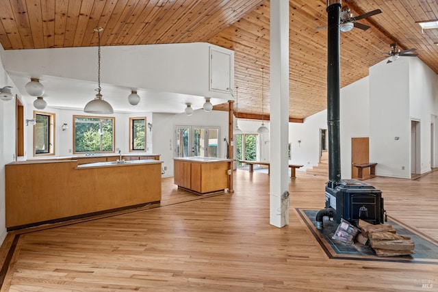 kitchen featuring a wood stove, wooden ceiling, and light wood finished floors