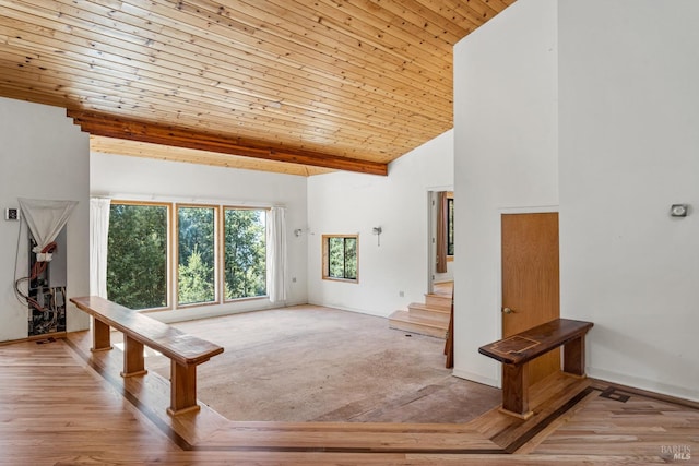 interior space with baseboards, wooden ceiling, light wood-style flooring, stairway, and high vaulted ceiling