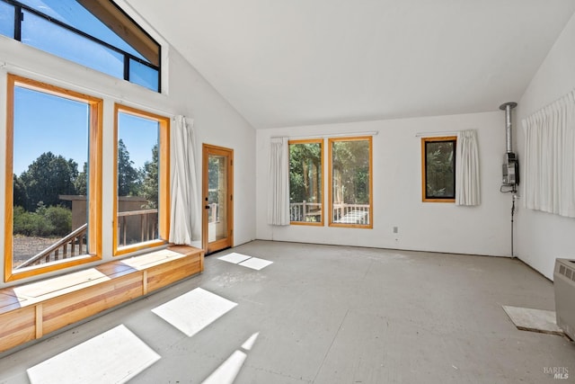 spare room featuring vaulted ceiling and concrete floors