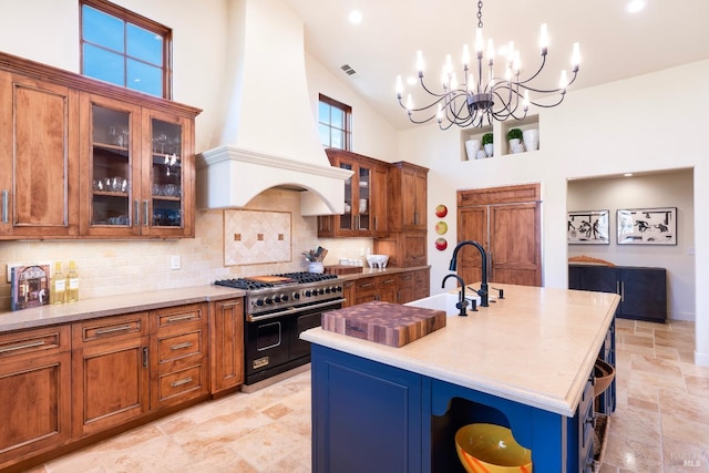 kitchen featuring brown cabinetry, custom range hood, double oven range, open shelves, and a sink