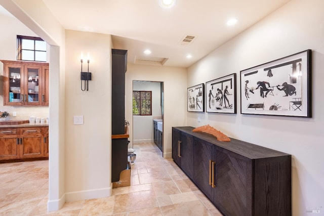 hallway featuring baseboards, stone tile flooring, attic access, and recessed lighting