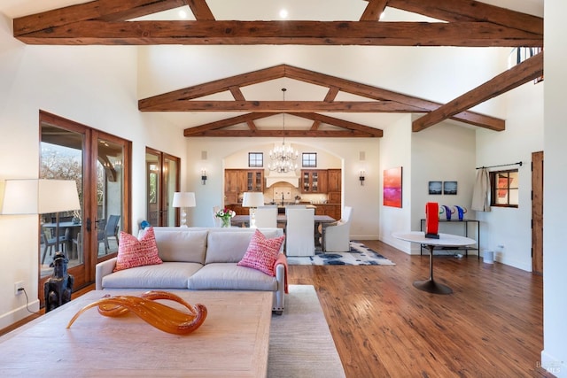 living area featuring baseboards, a chandelier, wood finished floors, high vaulted ceiling, and beam ceiling