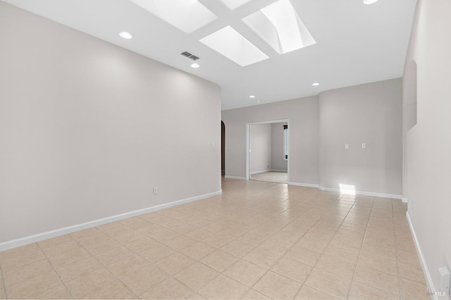 unfurnished room with arched walkways, recessed lighting, a skylight, and baseboards