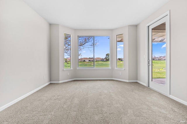 carpeted empty room with baseboards