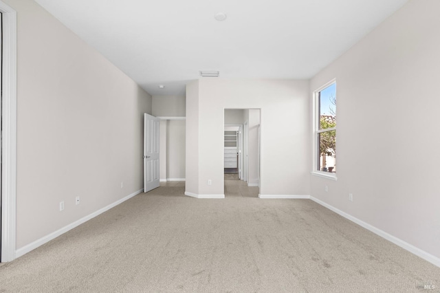 unfurnished bedroom with carpet floors, visible vents, a spacious closet, and baseboards