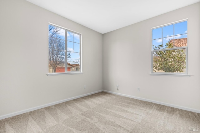 unfurnished room with light carpet and baseboards