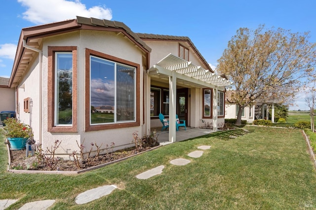 back of property with a patio area, a lawn, a pergola, and stucco siding