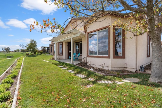 view of property exterior with a patio, a lawn, and stucco siding