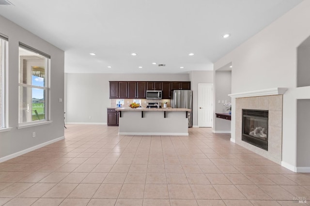 unfurnished living room with recessed lighting, light tile patterned flooring, a fireplace, and baseboards