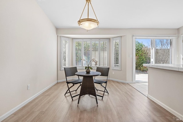 dining area with light wood-style floors and baseboards