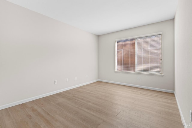 empty room featuring light wood-style floors and baseboards