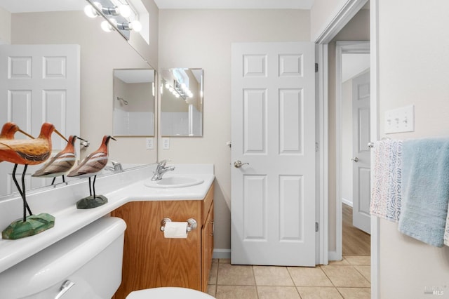 bathroom featuring toilet, tile patterned flooring, and vanity