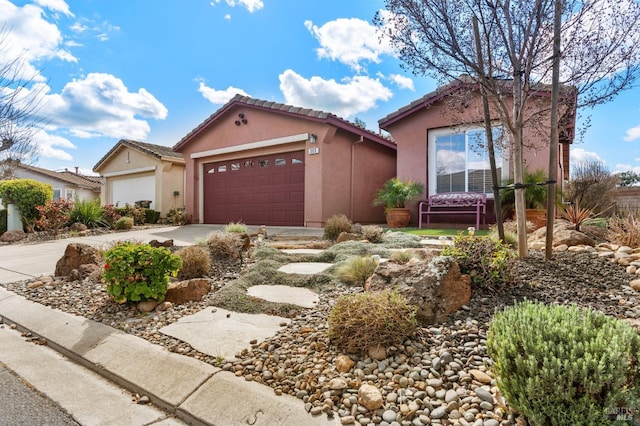 view of front of house featuring a garage, concrete driveway, and stucco siding