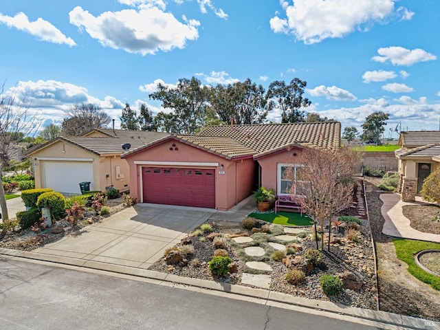 view of front of home featuring concrete driveway, a tiled roof, an attached garage, and stucco siding