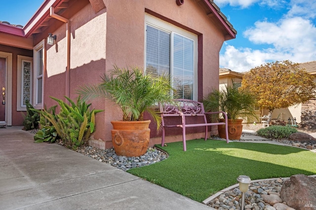 view of home's exterior with a lawn and stucco siding