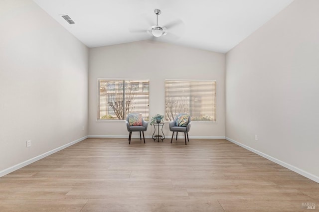 unfurnished room featuring lofted ceiling, light wood-style flooring, visible vents, baseboards, and a ceiling fan