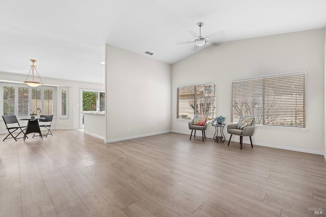 sitting room with vaulted ceiling, light wood finished floors, visible vents, and baseboards