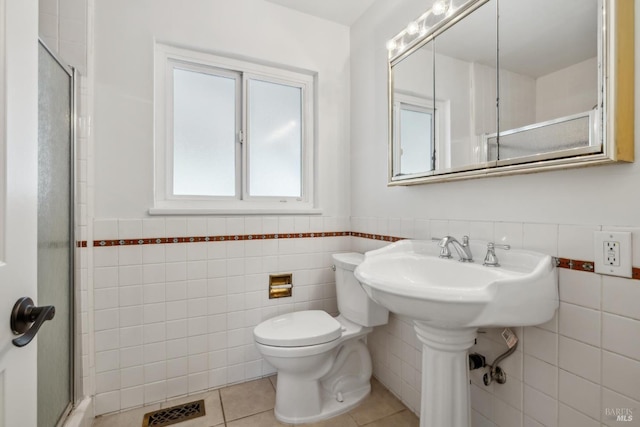 bathroom featuring a wainscoted wall, a stall shower, visible vents, and tile walls