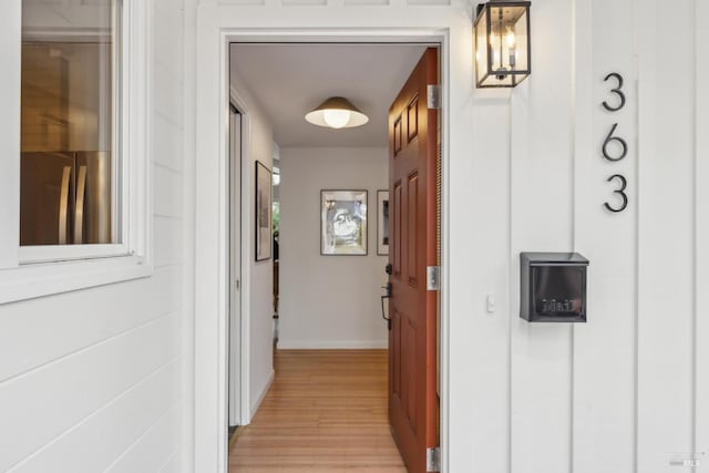 hall featuring light wood-style floors and baseboards