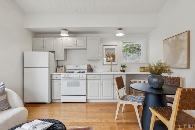 kitchen with light countertops, white appliances, wooden ceiling, and light wood-style flooring