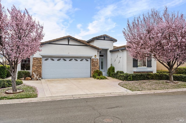 ranch-style home featuring a garage, stone siding, concrete driveway, and stucco siding