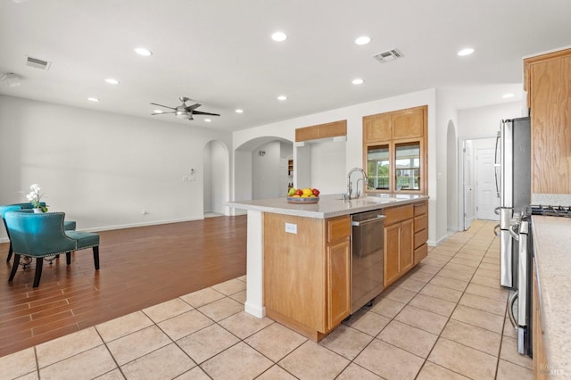 kitchen with appliances with stainless steel finishes, arched walkways, visible vents, and a sink