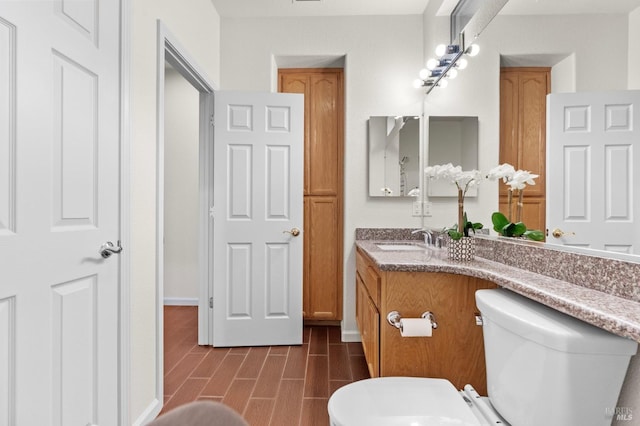 bathroom featuring wood finish floors, vanity, and toilet