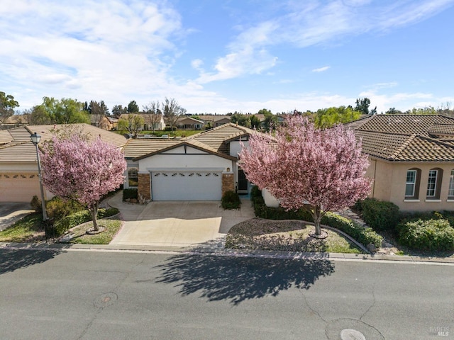 view of front of property featuring a garage, a tile roof, driveway, and stucco siding