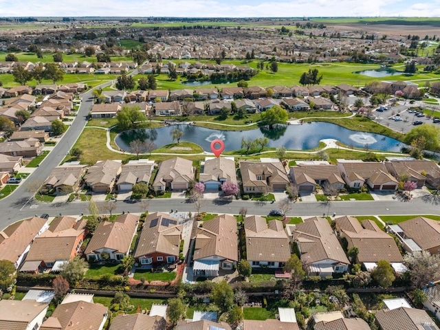 drone / aerial view with golf course view, a water view, and a residential view