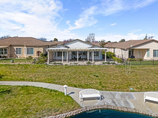 rear view of property featuring a yard, fence, stucco siding, and a patio