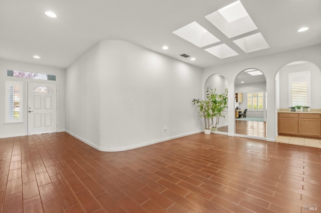 entryway featuring baseboards, wood finished floors, visible vents, and recessed lighting