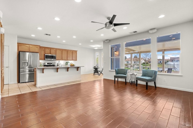 interior space featuring light wood-type flooring, visible vents, appliances with stainless steel finishes, and light countertops