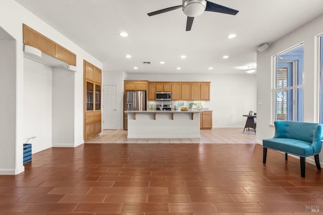 living room featuring baseboards, light wood-style floors, a ceiling fan, and recessed lighting