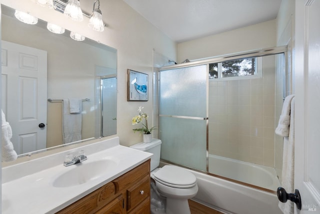 bathroom featuring toilet, enclosed tub / shower combo, and vanity